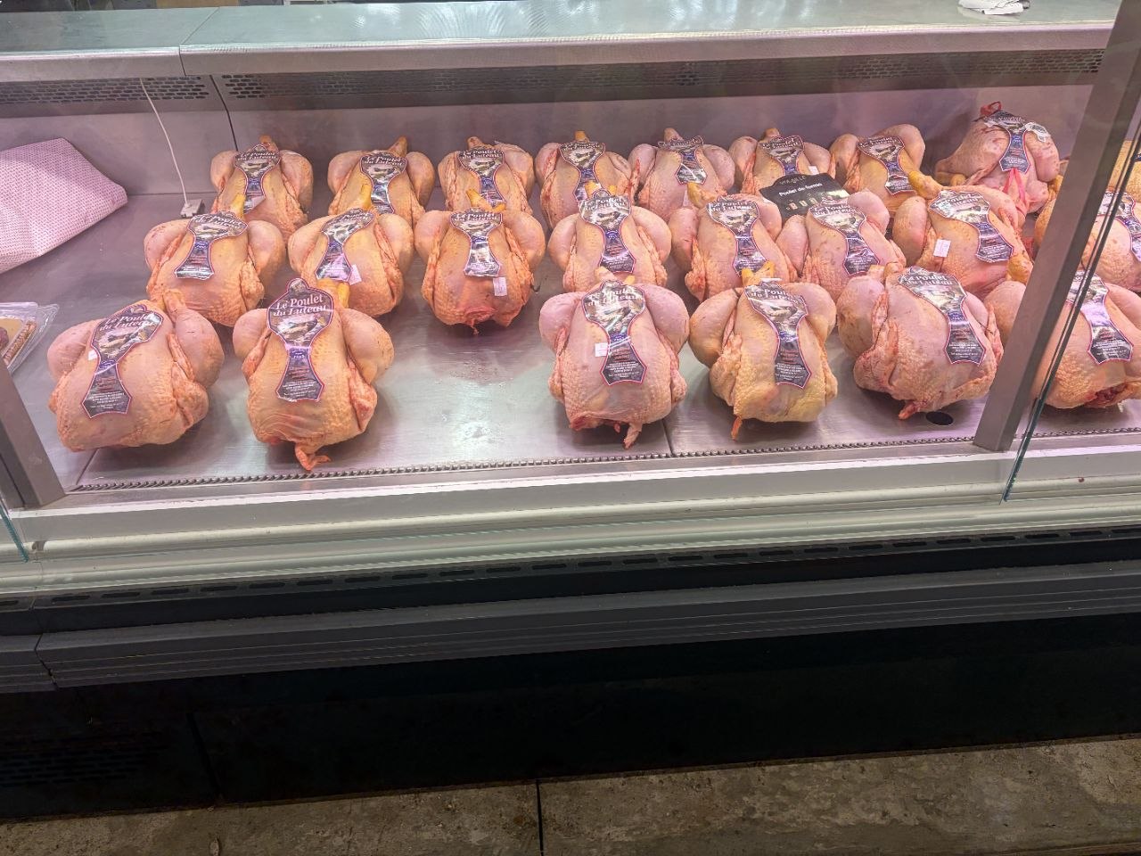 La vitrine réfrigérée : les poulets du Luteau alignés, étiquetés.